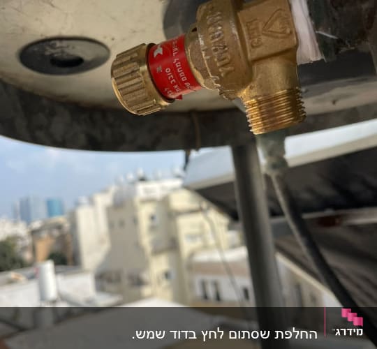 שסתום פליז עם תווית אדומה על דוד שמש